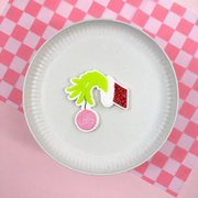 Grinch-Hand mit Christbaumkugel